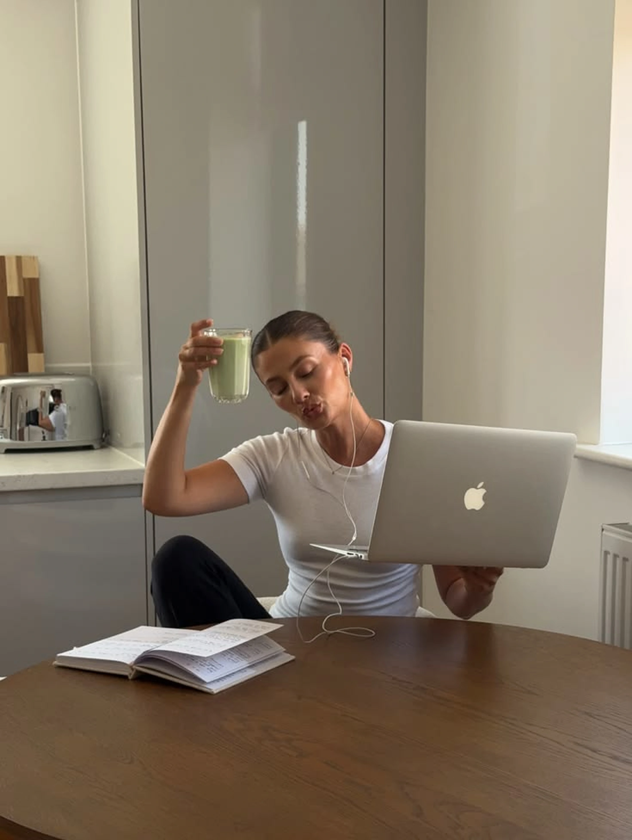 A woman working with a laptop and notes at a table